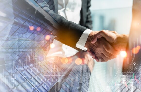 Business professionals shaking hands in front of modern financial data overlay, representing strategic partnerships and growth funding.