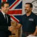 British businessman and American warehouse manager shaking hands in a US distribution center with “Paid in 48 Hours” clock and UK/US flags visible