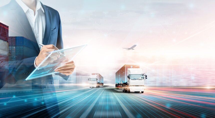 Businessman managing freight logistics with digital tablet, semi-trucks, and cargo containers