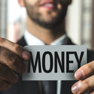 Businessman holding money sign symbolizing strategic borrowing and true cost of capital