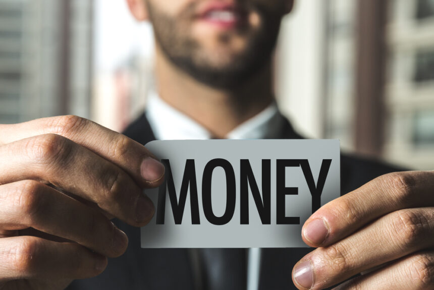 Businessman holding money sign symbolizing strategic borrowing and true cost of capital