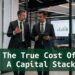 Two finance professionals reviewing capital stack cost analysis outside a modern boardroom