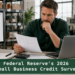 Small business owner reviewing financial reports in a warehouse; Federal Reserve 2026 Small Business Credit Survey